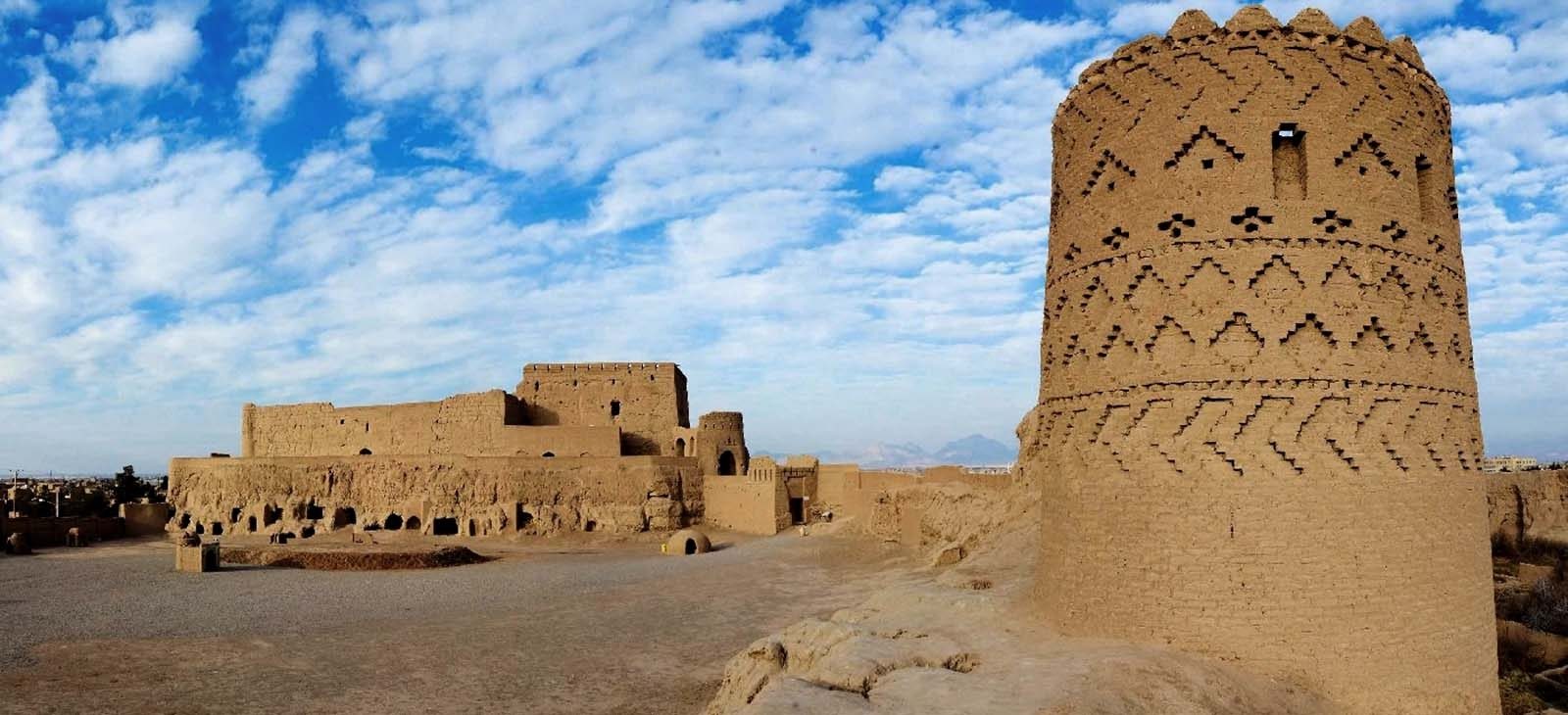 نمای پانورامای نارین‌قلعه میبد؛ برج نقش‌دار، حیاط باز و آسمان ابری
